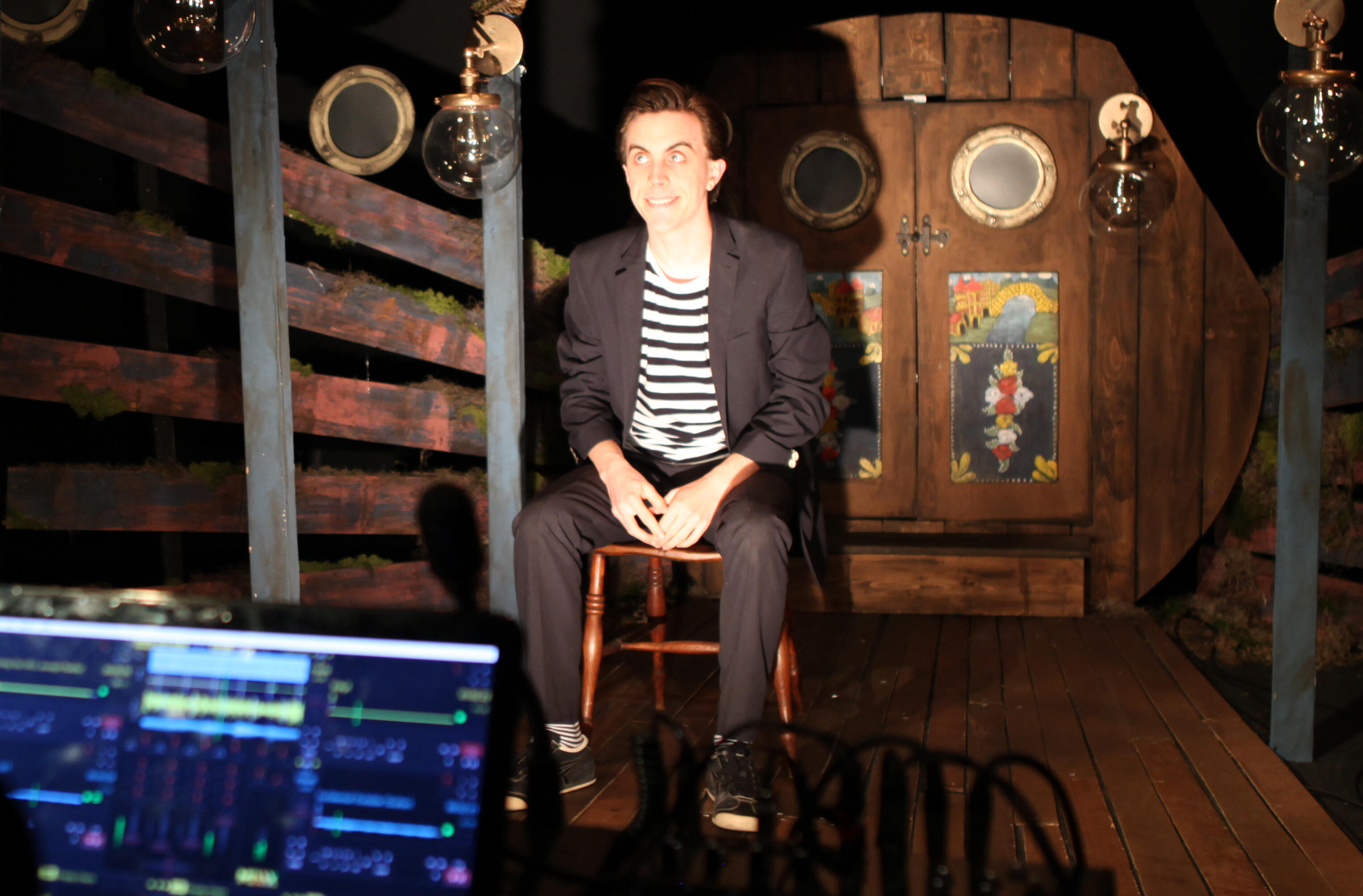 Felix sat in a fake narrowboat, a blurry laptop in the foreground